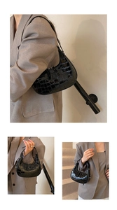 Detail of glossy black crocodile pattern hobo bag with polished silver-tone metal hardware