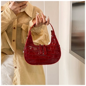 Detail of dark red crocodile embossed crescent hobo bag with dual zipper pullers