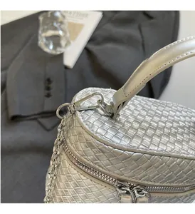 Detailed close-up of a silver woven texture box bag with polished metal hardware and chain