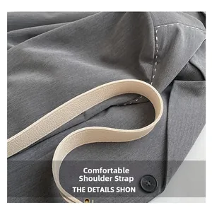 Detail view of comfortable cream leather shoulder strap on a grey textured bucket bag