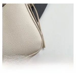 Close-up of litchi texture leather stitching on this cream bucket bag for women