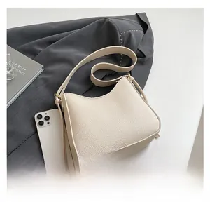 Close-up of off-white lychee grain leather hobo bag with gold hardware detail