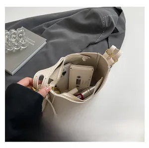 Spacious interior of textured leather bucket bag holding phone, lipstick and power bank
