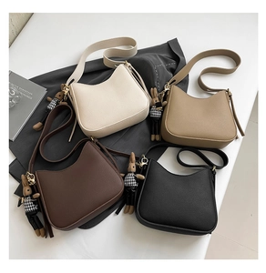 Flat lay of four minimalist leather shoulder bags in earth tones with bunny charms