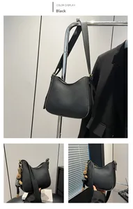 Detail of black pebbled leather bucket bag with golden hardware and cute rabbit charm