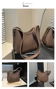 Detailed close-up of brown litchi grain leather texture and metallic zipper on hobo bag