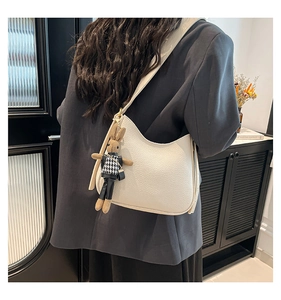 Détail du sac hobo en cuir grainé blanc avec un charmant lapin marron attaché à la bandoulière