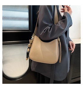 Hobo bag in beige lychee leather with cute plush rabbit charm on stylish model