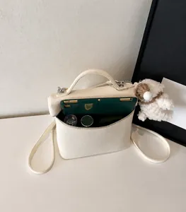 Vista superior del interior espacioso de un bolso de cuero beige con artículos diarios