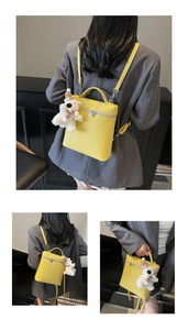 Mochila de cuero granulado amarillo con colgante de perro de peluche y cremallera de plata
