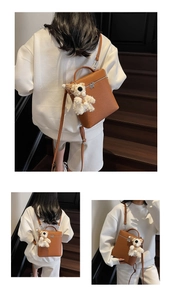 Detalle del bolso de cuero marrón con patrón litchi y colgante de oso de peluche