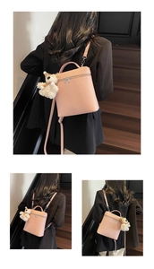 Detalle del bolso de cuero rosa con colgante de oso de peluche y cremallera metálica