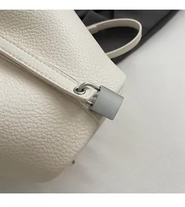 Detailed close-up of white lychee pattern leather and premium silver padlock hardware