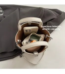 Spacious interior of beige lychee leather bucket bag with phone and coin purse