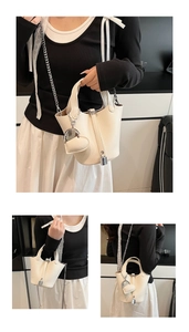 Detail of cream bucket bag with lychee texture, lock buckle and heart-shaped charm