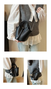 Detail of black lychee grain leather bucket bag with silver chain and heart charm