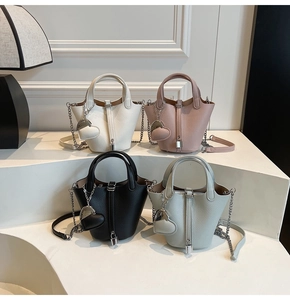 Close-up of four colors of pebbled leather bucket bags with heart charms and metal locks