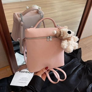 Bolso rosa con textura lichi, colgante de osito de peluche y cremallera doble plateada