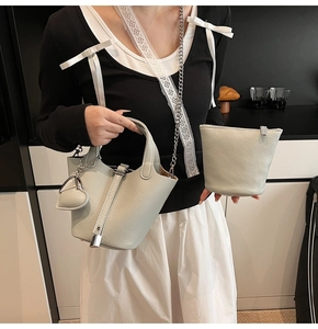 Detail of light blue lychee pattern leather bucket bag with silver lock and heart charm