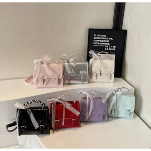 Detailed collection of shiny patent leather mini handbags with bow relief and lace ribbons