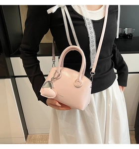 Pink mini leather crossbody bag featuring a heart pendant and Clearek logo branding