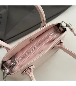 Detail view of the smooth silver zipper and secure magnetic snap on the pink handbag