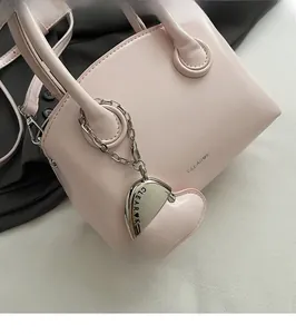 Detail of pink vintage bowling bag with CLEAR K logo and silver heart charm pendant