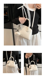 Detail of white arch handbag featuring CLEARVK logo and heart-shaped pendant accessory