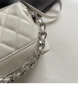 Dettaglio borsa a tracolla trapuntata beige con catena in metallo e pelle