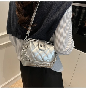 Borsa a tracolla trapuntata argento con catena in metallo indossata a spalla per un look moderno