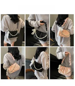 Detail shots of French pleated underarm bag with large pearl chain and lace bow charm