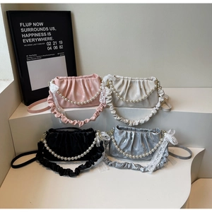 Detail of ruched satin handbags with pearl chains and lace bows in multiple colors
