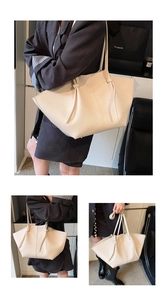 Close-up of beige tote bag featuring pebbled leather texture and decorative knot detail