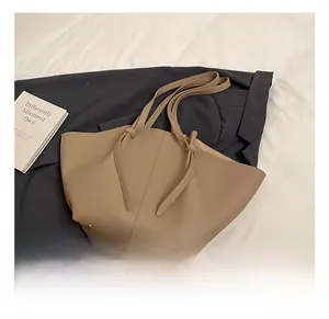 Detail of lychee pattern leather tote bag with knotted handle and metal rivet accents