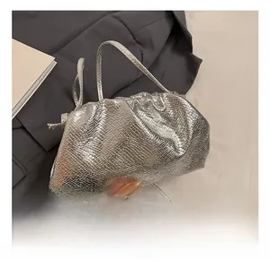 Detailed view of silver snakeskin texture on a drawstring cloud crossbody bag