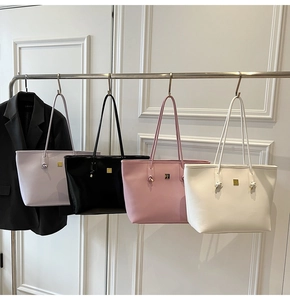 Close-up of minimalist large tote bags in lilac, black, pink, and white leather