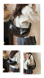 Detail of black pleated croissant bag with oil wax finish and knot shoulder strap