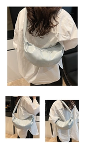 Detailed close-up of light blue pleated croissant bag showing soft leather texture and knots