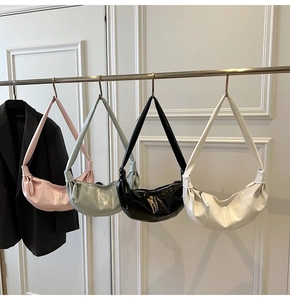 Group shot of four minimalist glossy leather dumpling crossbody bags in various colors