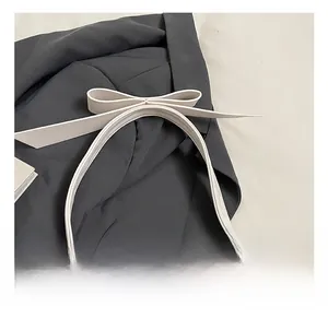 Détail de la décoration en nœud élégant sur un sac à bandoulière en cuir blanc plissé