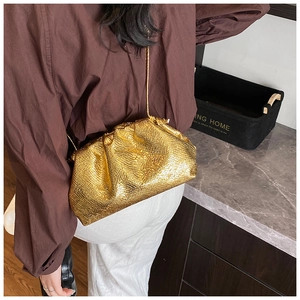 Detail of golden cloud pouch with python embossing and slim shoulder strap