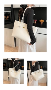 Detail of white glossy tote bag with gold logo on shoulder in a modern kitchen