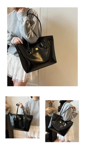 Detail of a large black oil wax leather tote bag with glossy finish and gold metal logo