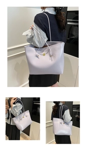 Detail view of light purple leather tote bag with elegant gold metal logo buckle