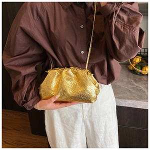 Close-up of golden cloud bag featuring snakeskin texture and pleated leather design