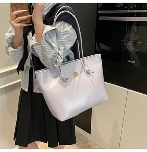 Detail of lavender leather tote bag with gold metal buckle and knotted strap on shoulder