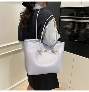 Close-up of light purple tote bag with knotted strap and gold logo in a modern kitchen