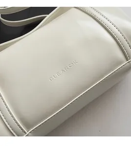 Detailed close-up of CLEAROK beige shoulder bag with soft lychee grain leather and embossed logo