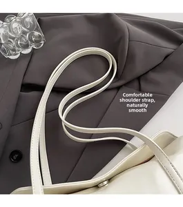 Close-up of comfortable shoulder straps on cream leather handbag with neat stitching