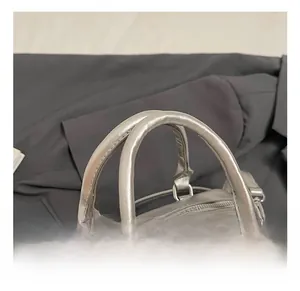 Detailed close-up of the silver cylindrical handles and zipper on the bowling handbag
